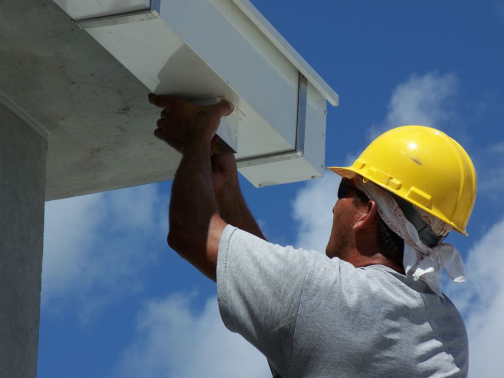 man installing commercial gutter